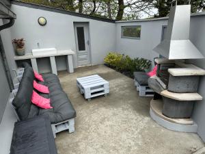 un patio con sofá, mesa y parrilla en La Louisine séjours du samedi au samedi, en Séné