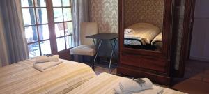 una camera d'albergo con due letti e uno specchio di Chambre d'Hote Les Touilles a Piégut-Pluviers