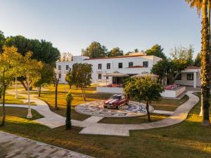een oude auto geparkeerd voor een wit huis bij 74 Otel in Antalya