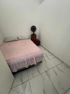 ein Schlafzimmer mit einem Bett und einem gefliesten Boden in der Unterkunft Casa MR Brutomesso 2 in Londrina