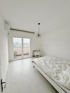 a white bedroom with a bed and a large window at Thomas House on Train Tracks in Venice