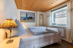 a bedroom with a bed and a lamp and a window at Doppelhaushälfte Ida in Meldorf