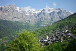a village in a valley with mountains in the background at Haus Rhodania in Albinen