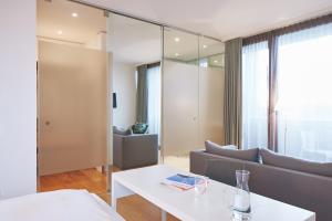 uma sala de estar com um sofá e uma mesa em Hotel am See em Hard