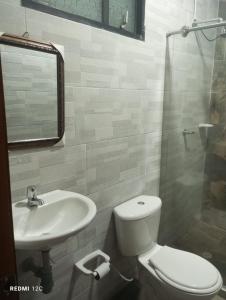 a bathroom with a toilet and a sink and a shower at Hotel Talauta Resort in Talauta