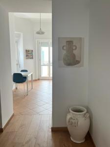 una habitación con una mesa y un jarrón en el suelo en Civico 18, en Bernalda