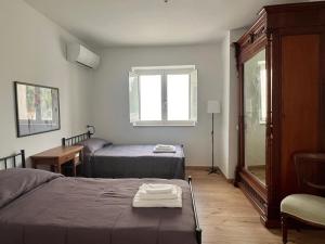 a bedroom with two beds and a window at Civico 18 in Bernalda