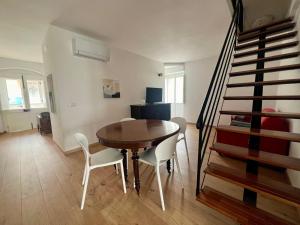 a dining room with a table and chairs and a staircase at Civico 18 in Bernalda