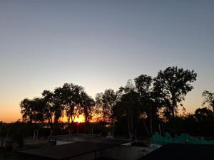 a sunset in the sky with trees in the foreground at Alquileres Guille in Colón
