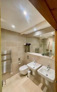 a bathroom with two sinks and a toilet and a mirror at The Wheel House in Penzance