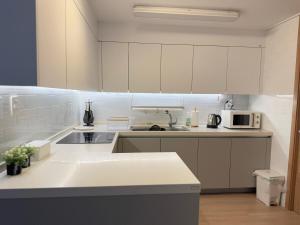 une cuisine blanche avec un évier et un micro-ondes dans l'établissement Everland Station 5 minutes on foot, Gamsung Accommodation Everland, Caribbean Bay, Korean Folk Village, Yongin Sevens, Stay Jal Jal, à Yongin 34 autres photos