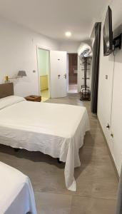 a bedroom with two beds and a door to a room at Habitaciones triple familiar HOTEL LAUAXETA in Mungia