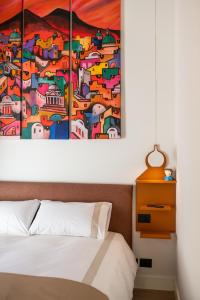 a bedroom with a painting on the wall above a bed at My Lodge Italy - Style and Comfort in Naples