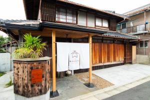 ein Gebäude mit einem Banner an der Vorderseite in der Unterkunft Kominka Wagaya in Higashiōsaka