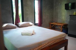 een bed met een handdoek op een kamer bij Bunma Homestay in Ban Khlong Sok