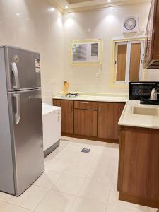 a kitchen with a stainless steel refrigerator and a sink at غزالي سويتس ghzali suites in Al Madinah