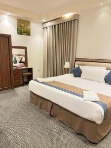 a hotel room with a large bed and a desk at غزالي سويتس ghzali suites in Al Madinah