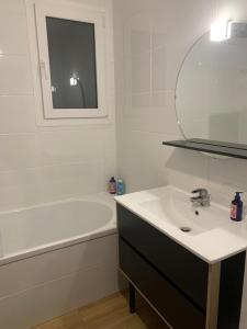 a white bathroom with a sink and a bath tub at Charmante maison au calme proche de Paris in Achères