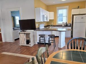 a kitchen with a kitchen island with chairs and a table at The Monarch - 4 Butternut in Cherry Valley
