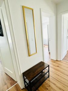 3Rooms Central Modern near MTU- Lakescape FeWos في فريدريشسهافن: غرفة مع طاولة ومرآة على الحائط