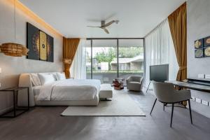 a bedroom with a bed and a living room with a desk at Luxury Penthouse 407sqm Beachfront and private pool in Phuket Town