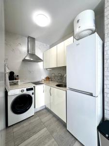 a kitchen with a white refrigerator and a dishwasher at Starfish Home in Costa Del Silencio