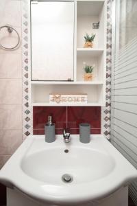 a bathroom with a white sink and a mirror at LakeSide Apartment in Kastoria