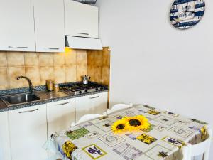 una cocina con una mesa con un girasol. en Condominio Athena, en Bibione