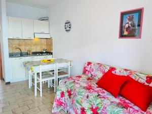 Una sala de estar con un sofá y una cocina. en Condominio Athena, en Bibione