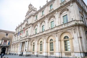 a large building with people standing in front of it at Palazzo Bicocca Rooms in Catania +35 photos