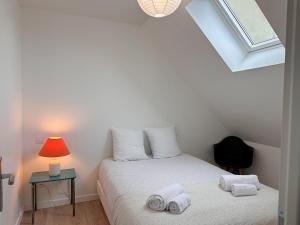 a bedroom with a bed with towels on it at Appartement 2 chambres- 10 mn d'Orléans - Le Nid de la Pointe - in Saint-Pryvé-Saint-Mesmin