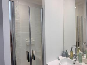 a bathroom with a glass shower door next to a sink at Appartement 2 chambres- 10 mn d'Orléans - Le Nid de la Pointe - in Saint-Pryvé-Saint-Mesmin +16 photos