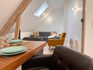 a dining room with a table and a couch at Appartement 2 chambres- 10 mn d'Orléans - Le Nid de la Pointe - in Saint-Pryvé-Saint-Mesmin