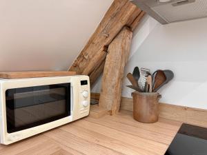a microwave oven sitting on top of a wooden floor at Le Nid de la Pointe - Appartement 2 chambres in Saint-Pryvé-Saint-Mesmin