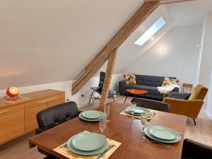 a dining room with a table and a couch at Le Nid de la Pointe - Appartement 2 chambres in Saint-Pryvé-Saint-Mesmin +17 photos