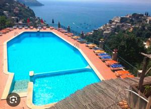 a swimming pool with chairs and a view of the ocean at Casa Alessia in Positano