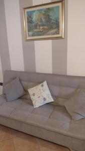 a couch with a pillow sitting under a painting at LA PETITE MAISON in Fucecchio +30 photos