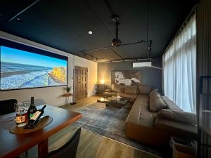 a living room with a couch and a large screen at The Hills Suite Daikanyama & Omotesando-Shibuya-Harajuku-Meiji Shrine & 10-minute walk from Daikanyama in Tokyo
