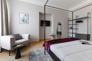 ローマにあるPiramide Deluxe Apartmentのベッドと椅子のある寝室