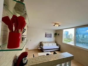 a living room with a couch and a vase with flowers at Vista Inesquecível de São Paulo! in Sao Paulo