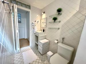 a white bathroom with a toilet and a sink at Vista Inesquecível de São Paulo! in Sao Paulo