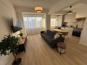 a living room with a couch and a table and a kitchen at The Crow Ajuda Apartment I in Lisbon +5 photos