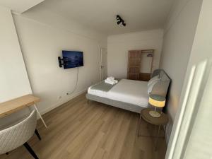 a small bedroom with a bed and a chair at The Crow Ajuda Apartment I in Lisbon