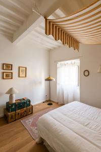 Un dormitorio con una cama blanca y una ventana. en Inn Oltremare - appartamento di design a un passo dal centro e dal mare, en Livorno