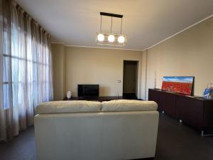 a living room with a large white couch in front of a window at Chicco family - Appartamento spazioso per famiglie e soggiorni business - Cinelli Apartment in Vercelli