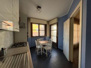 a kitchen with a table and a stove top oven at Chicco family - Appartamento spazioso per famiglie e soggiorni business - Cinelli Apartment in Vercelli