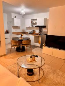 a living room with a table and a kitchen at Cosy T2 neuf avec balcon Proche centre & plage in Montpellier +5 photos