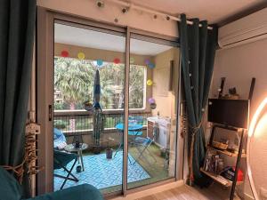 a room with a sliding glass door to a patio at Studio Paradise entre mer et pins in Saint-Raphaël