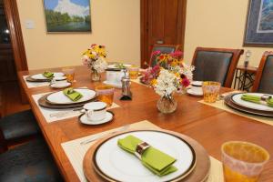 una larga mesa de madera con platos y flores. en Danby House, en Markdale