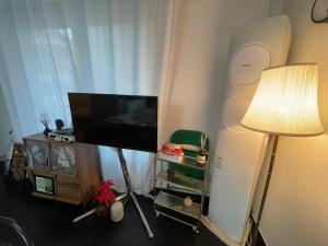 Habitación con TV de pantalla plana y lámpara. en Goyo inn Sillim, en Seúl